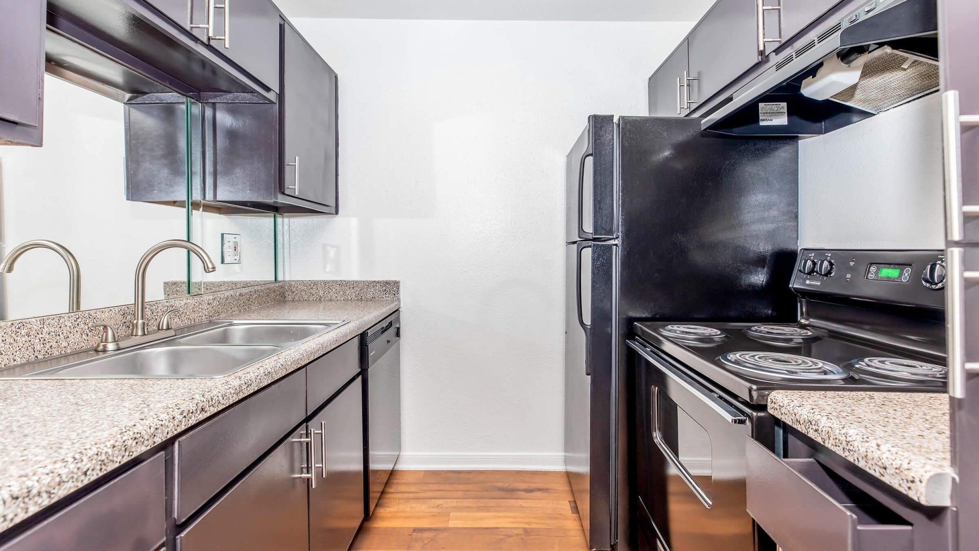 a kitchen with a stove, refrigerator, sink and cabinets